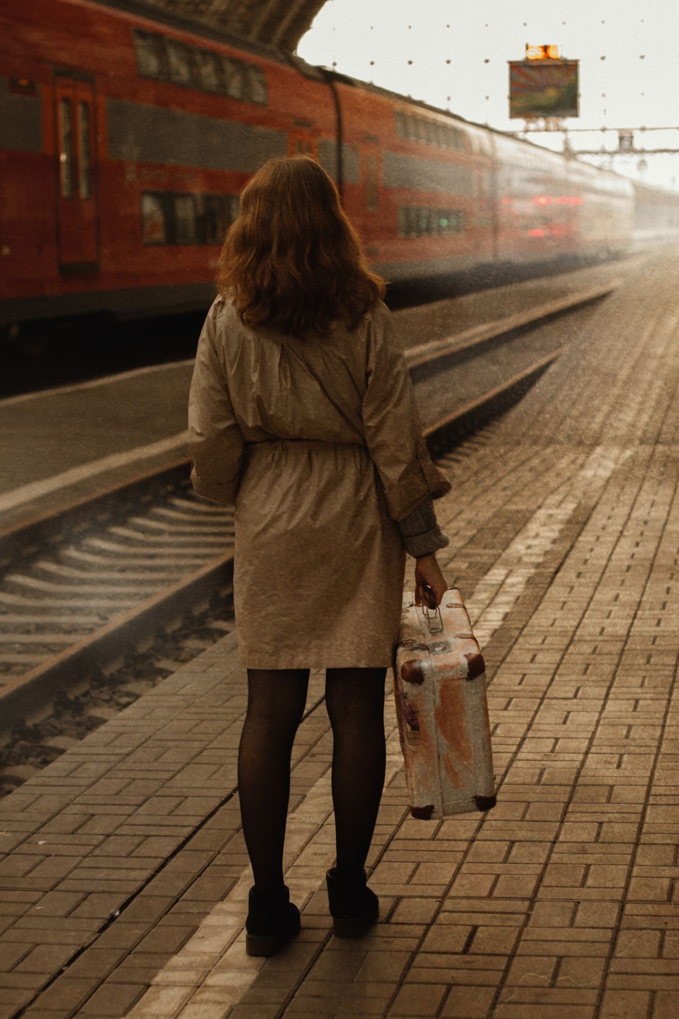 Traveler standing beside a passenger train at a platform