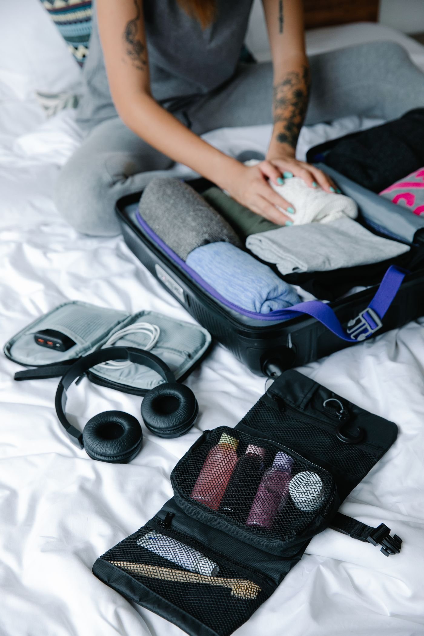 A traveler organizing clothes in an open suitcase